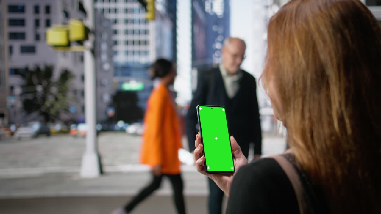 Display verticale con chroma key tenuto da un adulto vicino a un gruppo di pedoni che camminano