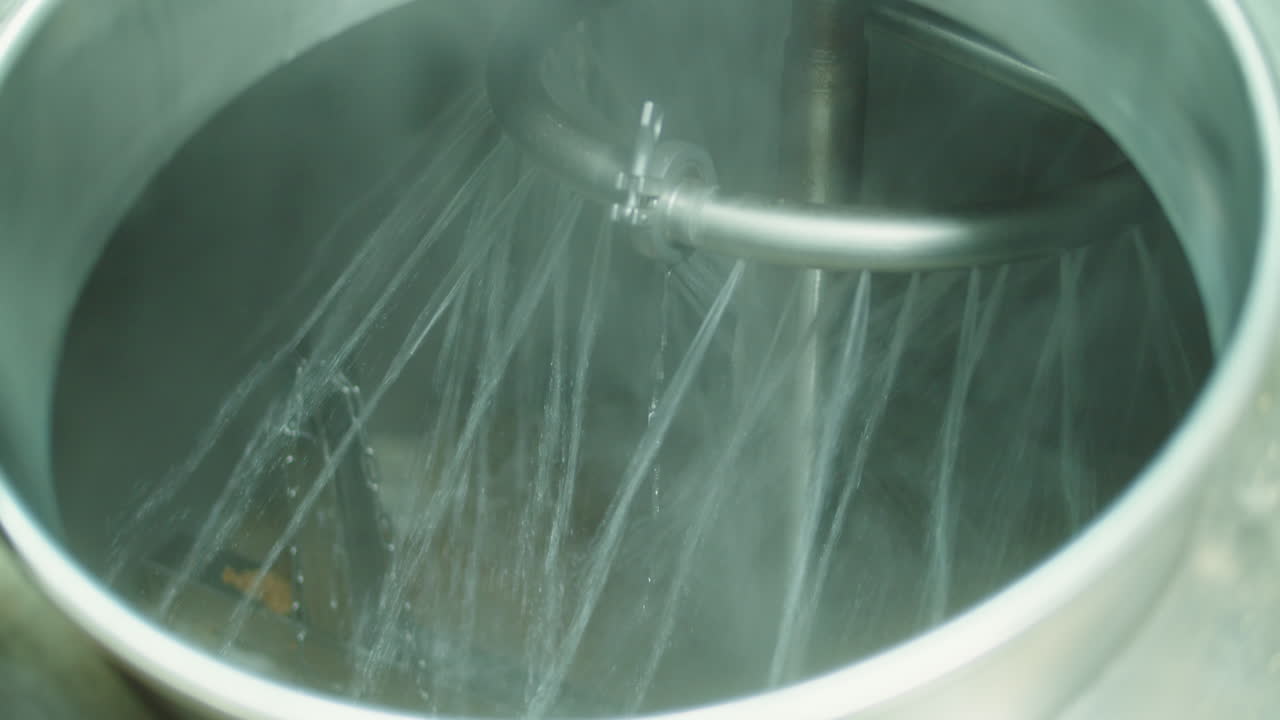 Craft beer production factory, brewery manufacture. Putting barley malt grains close-up. Brewing, cooking alcohol in metal vats bottles