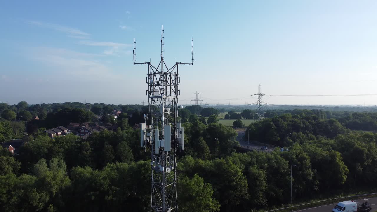 antena de torre de radiodifusión 5g en el bosque de la campiña británica con vehículos que viajan en el fondo de la carretera vista aérea ascendente