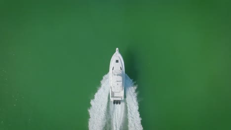 a yacht gracefully sails through the green sea off the coast of miami, where white waves break against its hull