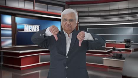 un periodista indio enojado mostrando los pulgares hacia abajo