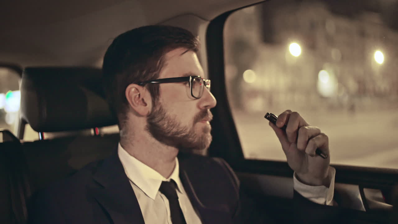 차 뒤에 있는 사업가가 전화를 받는다