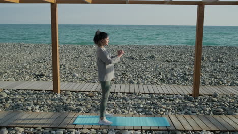 woman doing squats on a beach