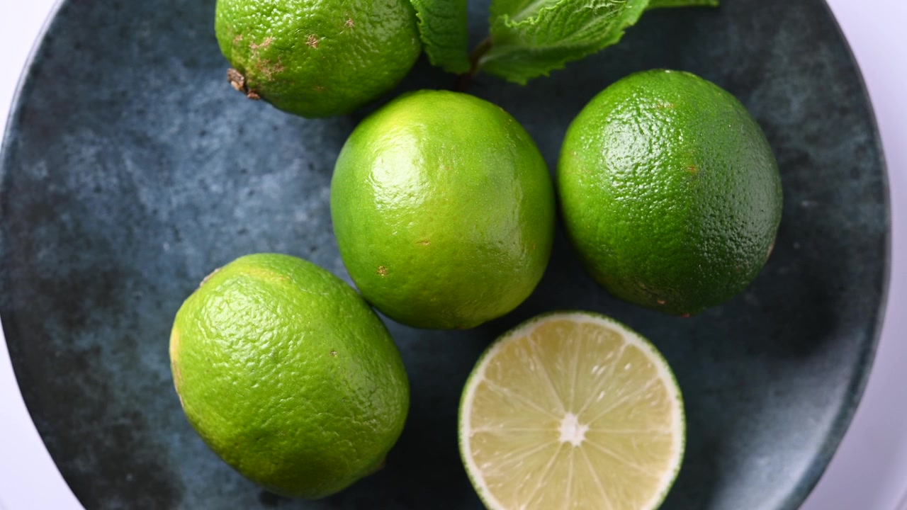 Limette fresche che ruotano su un piatto in primo piano