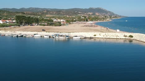 Aerial-drone-shot-of-a-wave-breaker-in-a-sunny-day-overlooking-the-mediterranean-ocean-in-Kavala-Greece