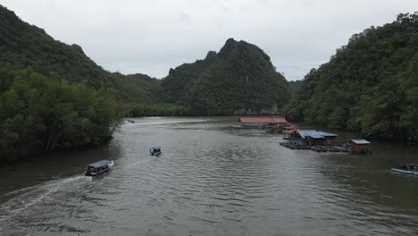 Aerial-follows-tourist-boats-on-picturesque-jungle-karst-waterway
