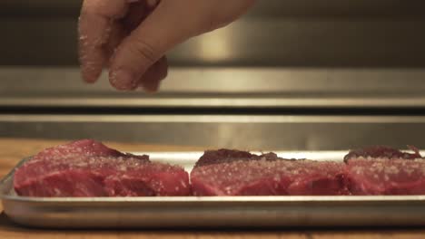 Salt-sprinkle-on-raw-tuna-fillet-in-slowmotion-close-up-macro