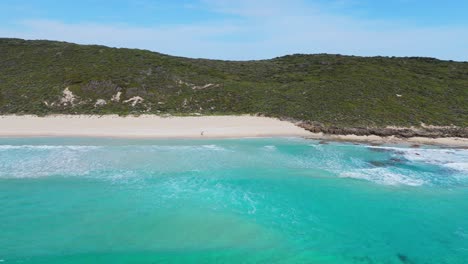 Couple-walking-along-long-stretch-of-white-sand-beach-on-Margaret-Rivers-Cape-to-Cape-track-on-summers-day