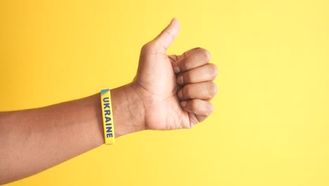 hand with ukraine wristband showing support