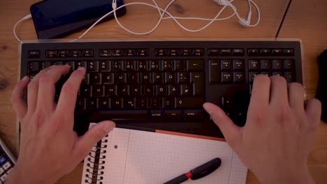 el joven está escribiendo un texto en su computadora usando un teclado-5