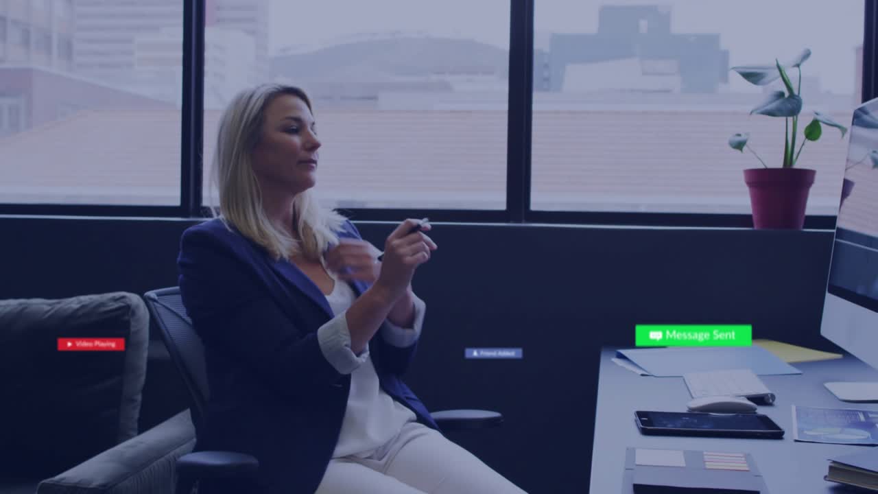 Mature woman at business desk, noticing play icon near hand tapping midair controls managing popups