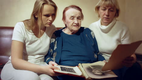 daughter mother and grandmother looking through family photos