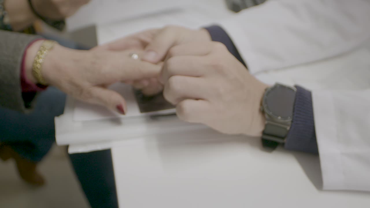 A doctor carefully examines the hands of an elderly person to ensure everything is fine