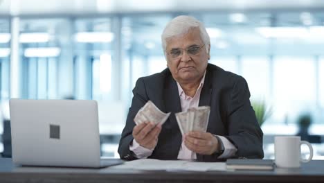 indian senior businessman counting money