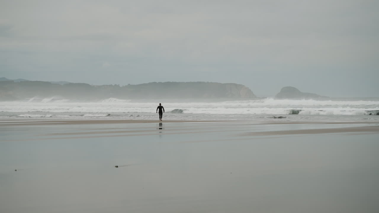 Surfer on a cloudy beach