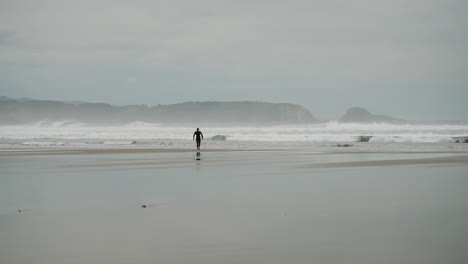 surfer on a cloudy beach