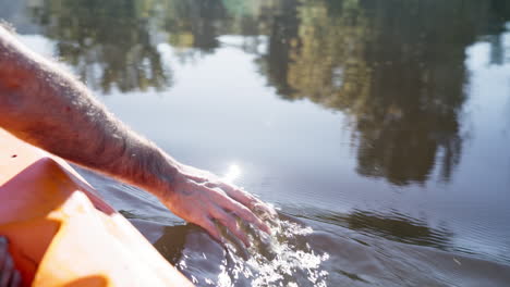 sailing, boat and hands in the water of a lake