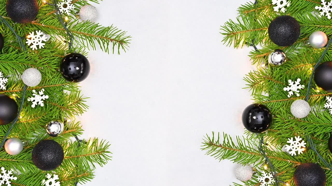 decoración de navidad blanca y negra en ramas de pino con luces parpadeantes en el lado izquierdo y derecho.