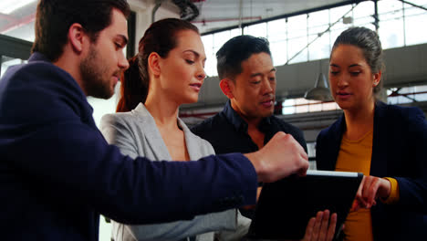 business executives discussing over digital tablet