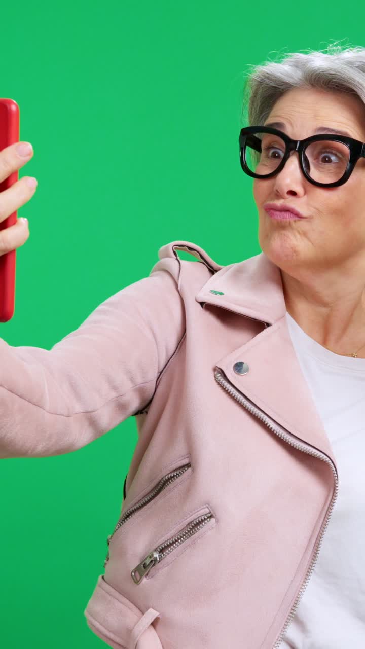 Senior Woman Taking Selfies and Making Funny Faces on Green Screen