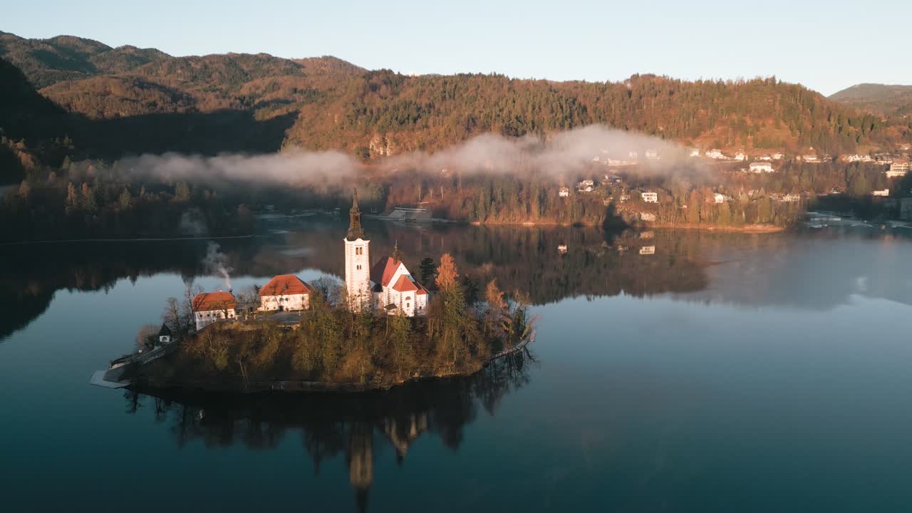 Eine ruhige Drohnen-Luftaufnahme zeigt die prächtige Kircheninsel im Bleder See an einem kühlen Wintermorgen