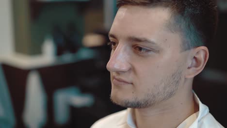 young man is made a hairdo in a barber shop the hair is laid with foam a close-up