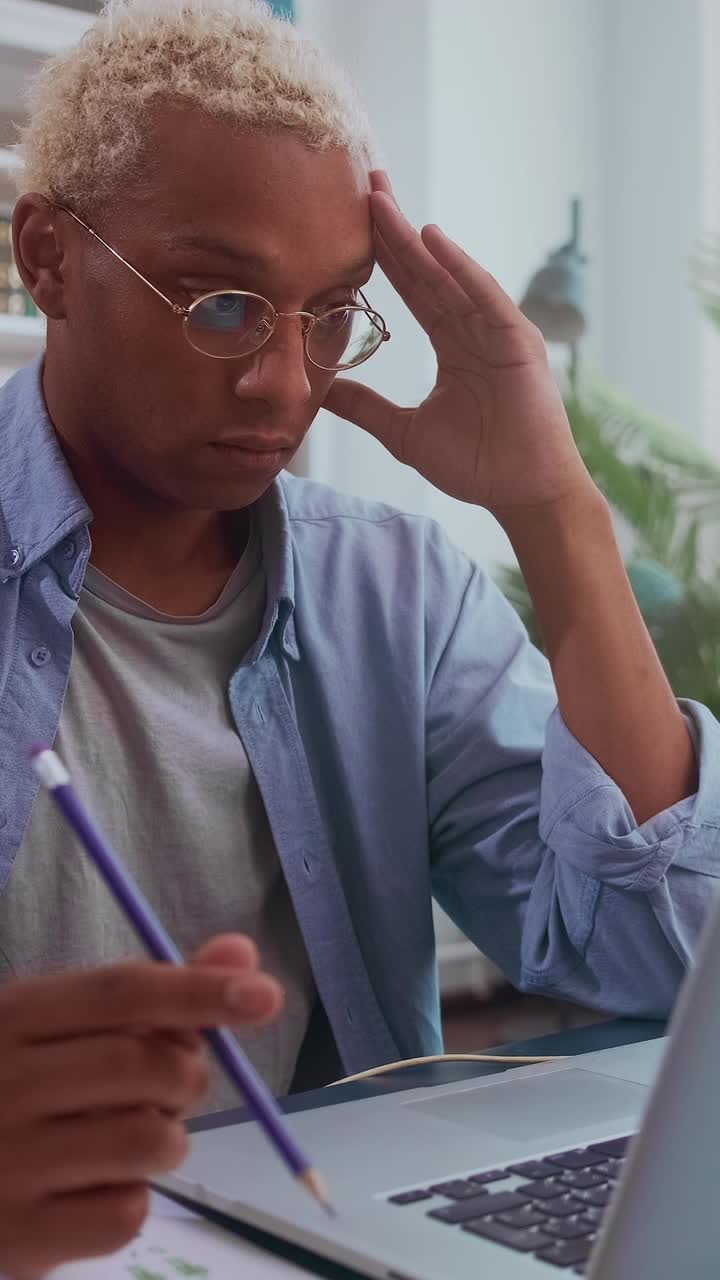 Young african american man studying intently at home during the afternoon