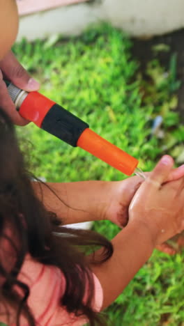 padre ayudando a su hija a lavarse las manos
