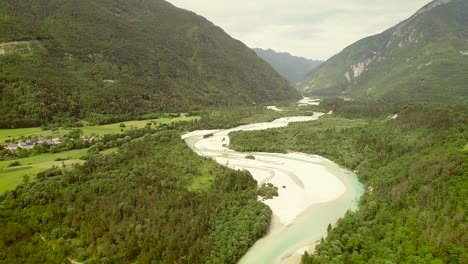 vista aérea del río soca rodeado por una pequeña ciudad y muchas colinas en eslovenia.