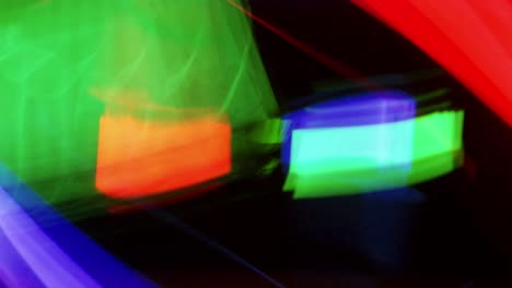 the blurry motion of red green and blue streak light is fast moving on a black background.