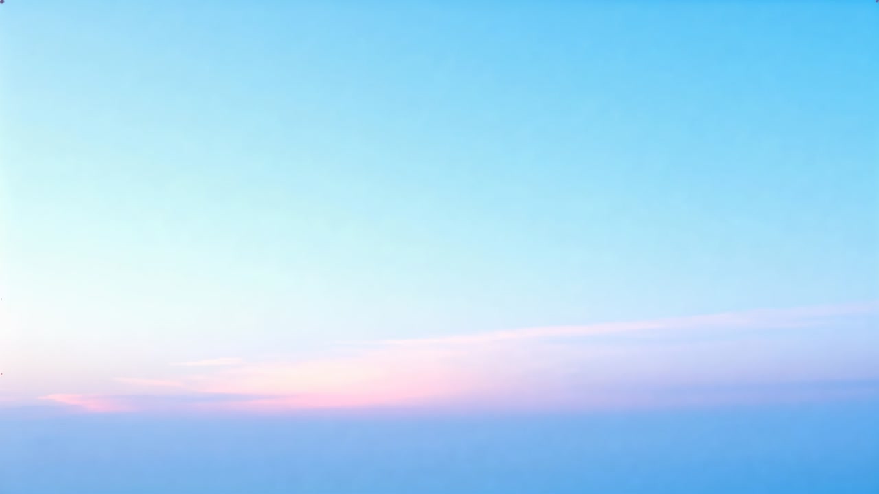 Showing clear blue sky and low cloud layer brightening at altitude from sunrise light, pink band