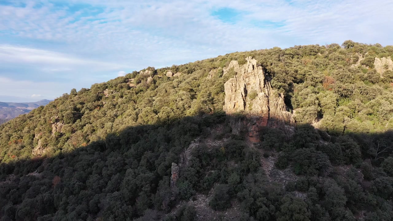 Filmato aereo con drone di una cresta montuosa boscosa con scogliere rocciose e paesaggi boschivi densi nel Medio Atlante, Marocco, ideale per progetti documentaristici su viaggi, natura e aree selvagge.
