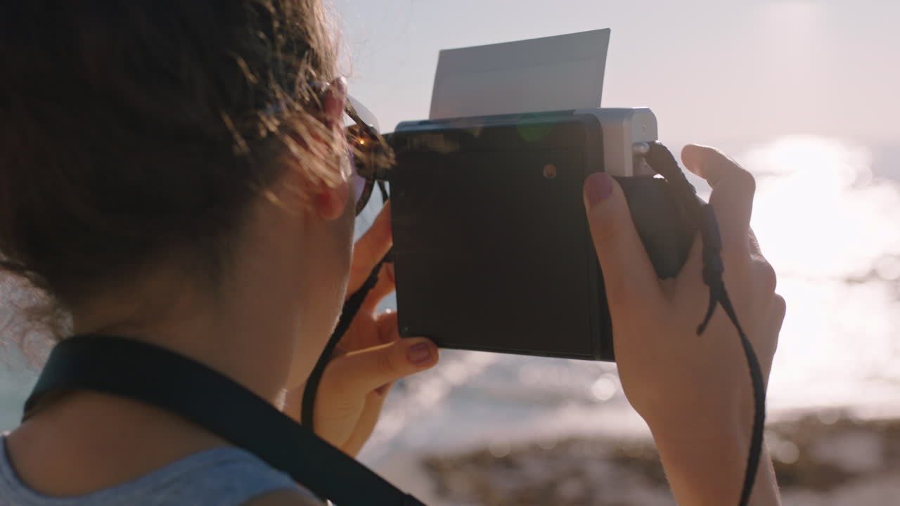 joven fotógrafa tomando fotos en la playa usando una cámara retro disfrutando del día de vacaciones de verano joven fotografiando la hermosa orilla del mar
