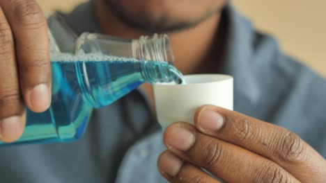 person pouring mouthwash