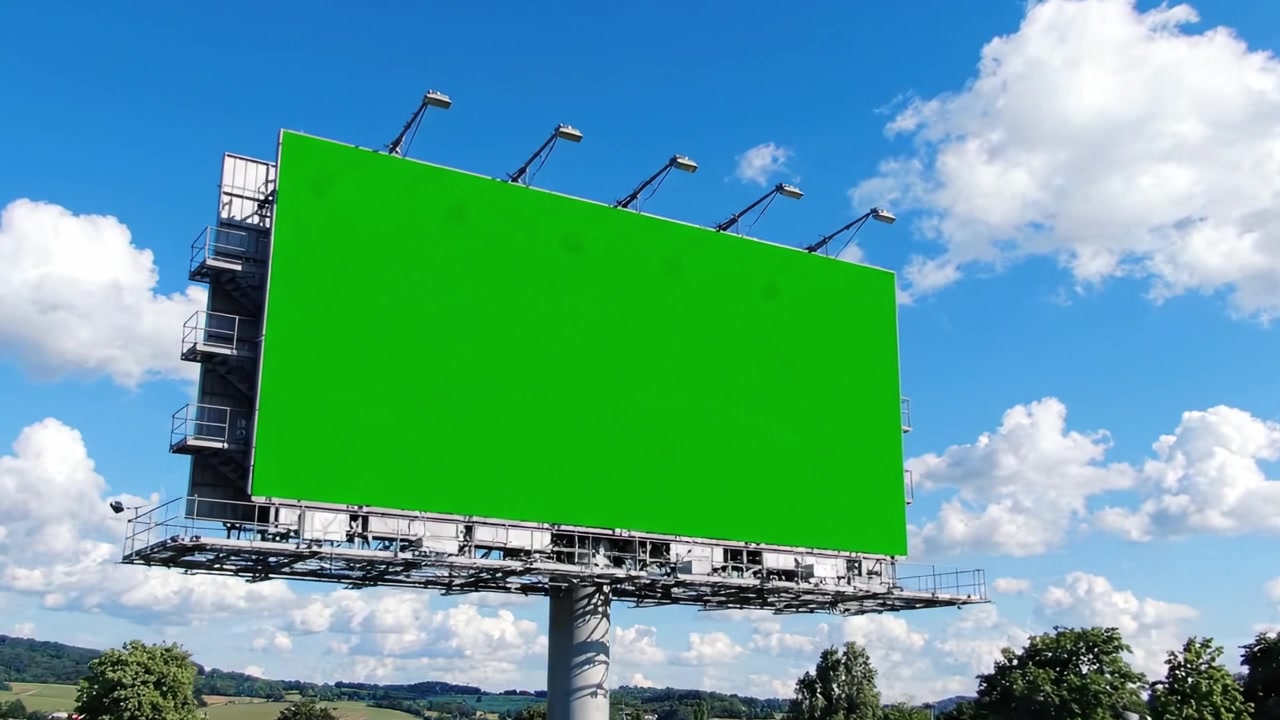 En række urbane billboards, der viser en levende grøn skærm mod en klar blå himmel med bløde hvide skyer, ideel til reklame eller kampagner