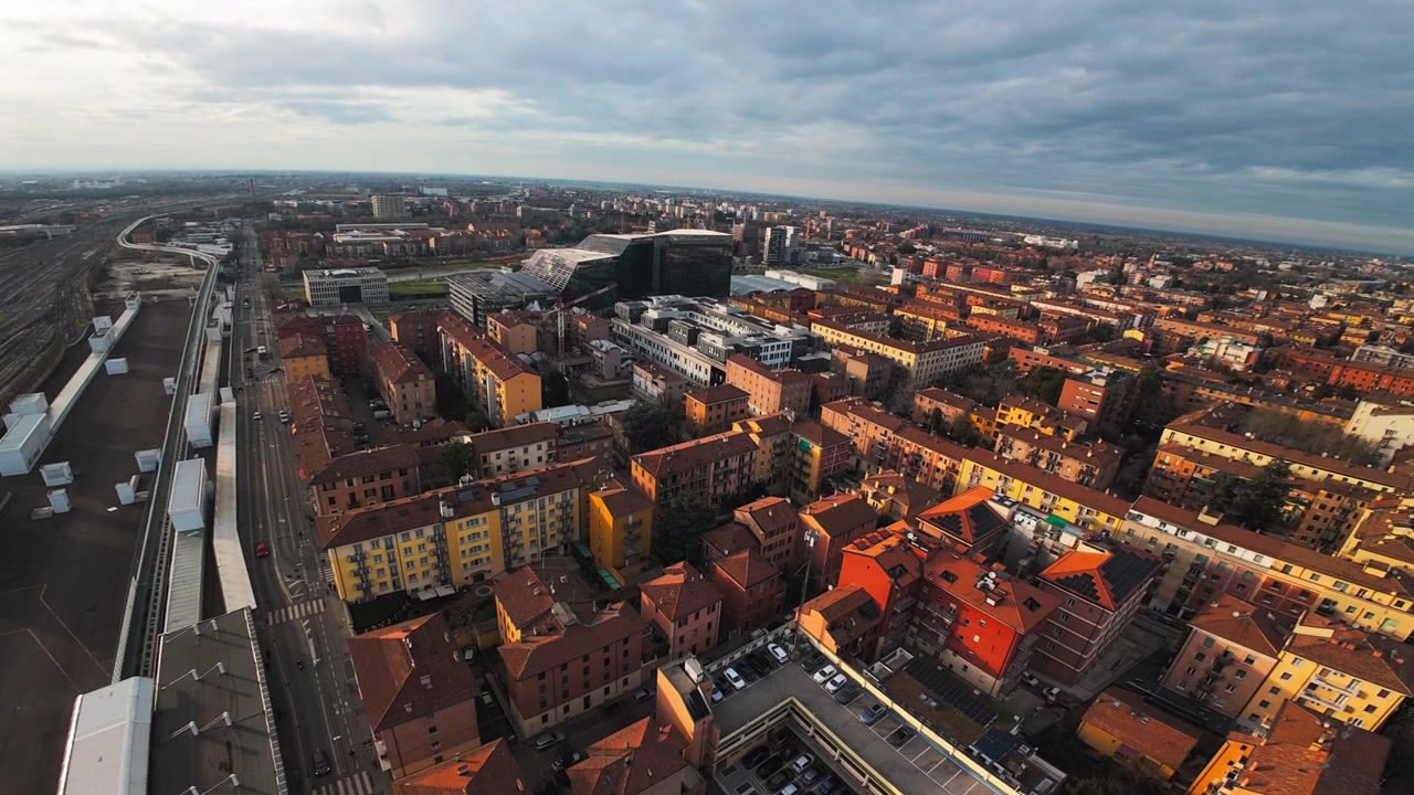 Sorvolo con drone sopra la città di Bologna, Italia. La ripresa cattura i binari della stazione ferroviaria, gli edifici residenziali e il moderno edificio del municipio, Palazzo Bonaccorso.