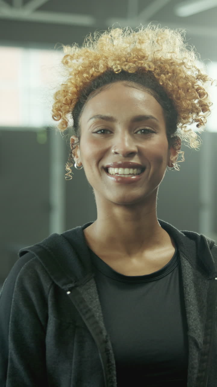 Retrato de uma Jovem Mulher Feliz com Cabelo Loiro Cacheado e Sorridente