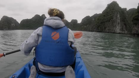 POV-shot-of-a-woman-in-a-kayak,-paddling-seen-from-the-back