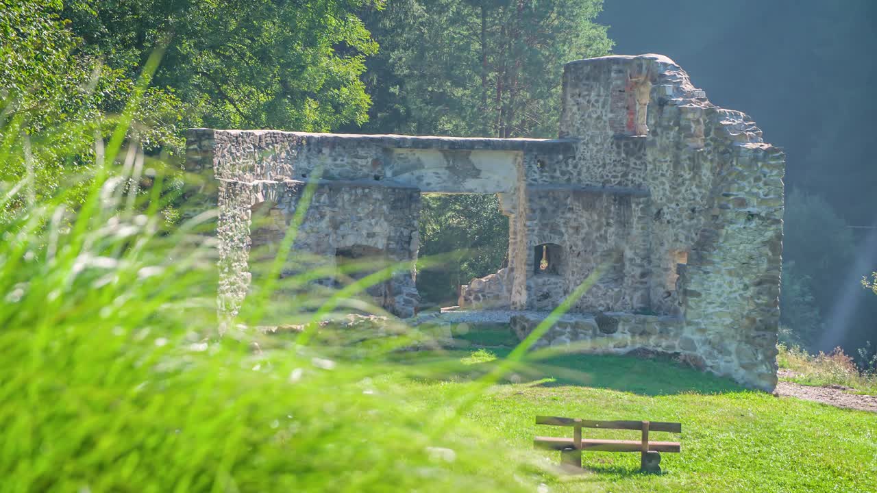 Couple Hiking Past Ruins In Vuzenica, Slovenia In The Distance. Slow Motion