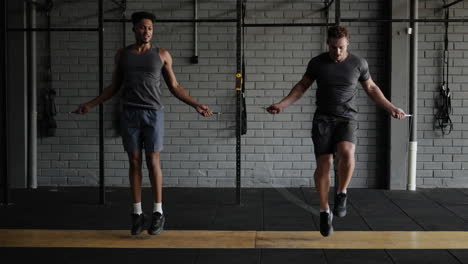 dos hombres saltando la cuerda en un gimnasio