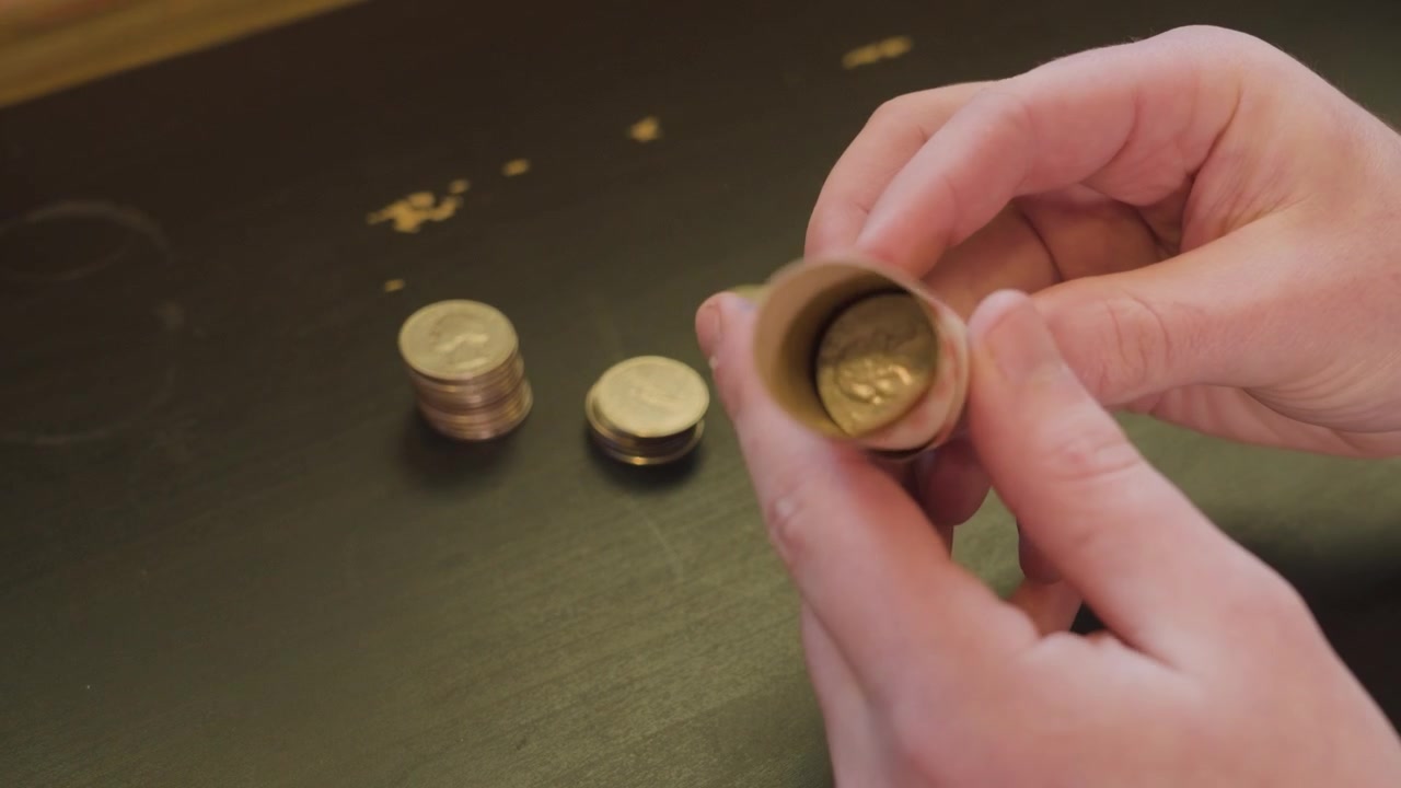 Riempire parzialmente un rotolo di monete con quarti di dollaro.