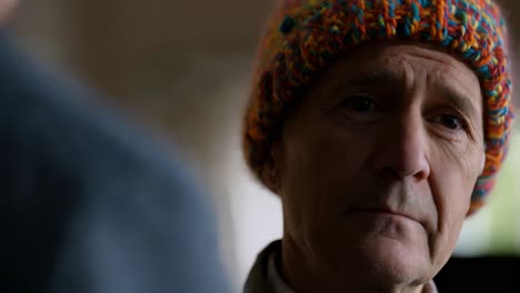 close-up portrait of a thoughtful senior man wearing a colorful hat