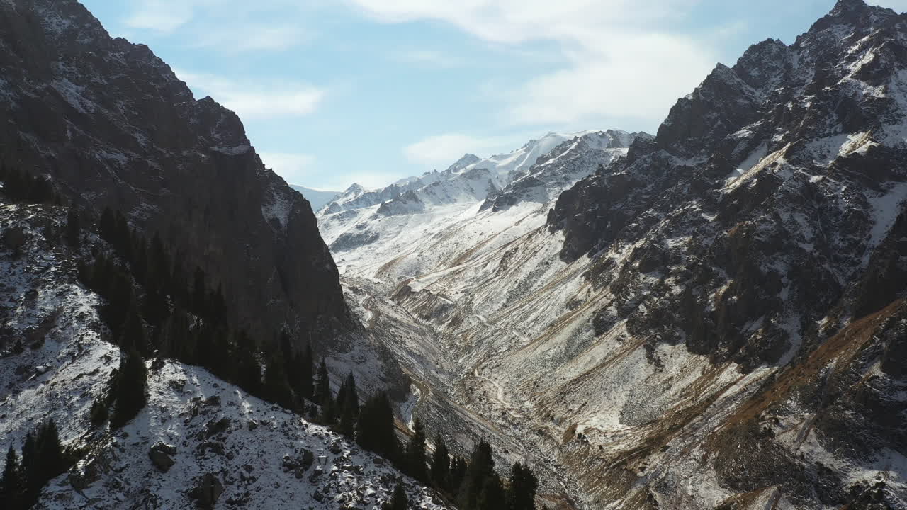 Rekaman drone sinematik yang menyingkap pegunungan Trans-Ili Alatau yang tertutup salju di Kazakhstan