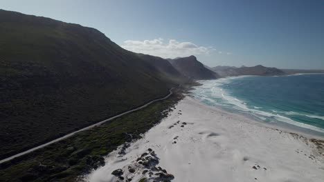 carretera de la ladera de la montaña cerca de los acantilados brumosos y scarborough en la playa de witsand, península de cabo, ciudad del cabo, sudáfrica