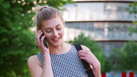 Businesswoman-Talking-On-Mobile-Phone-Outside-Office