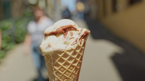 centrarse en el helado en el cono crujiente derretimiento durante el día caluroso, alejar el zoom
