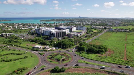 Luftaufnahme-Der-Croisette-Auf-Mauritius-Mit-Einem-Belebten-Kreisverkehr,-Grünen-Landschaften-Und-Weit-Entferntem-Meerblick,-Heller-Tag