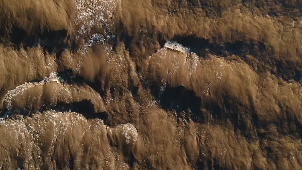 un río fangoso que fluye rápidamente creando ondas y patrones a partir de la corriente que fluye rápidamente