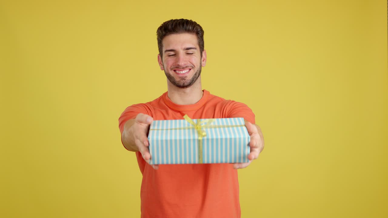 Man Smiling and Presenting a Gift Box