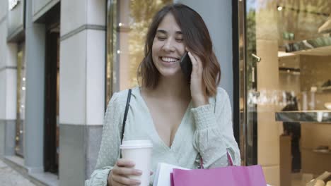mujer latina alegre hablando por celular y sonriendo